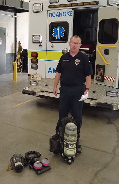 Brian Clingenpeel stands next to Respiration Devices on the floor