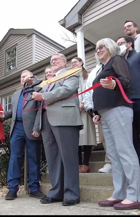 Employees at Neely's about to cut a ribbon for grand opening.
