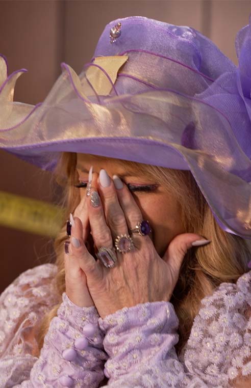 Woman crying wearing lilac colored clothing
